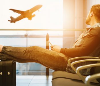 man sitting on chair looking at airplane